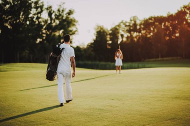 Baba küçük kızı ile golf sahasında oynuyor... Golf Club civarındaki rahatlatıcı. Spor yaz. Yaz aylarında açık eğlenceli. Aile eğlencesi. Sağlıklı yaşam konsepti. Küçük kız. Yeşil çimen.