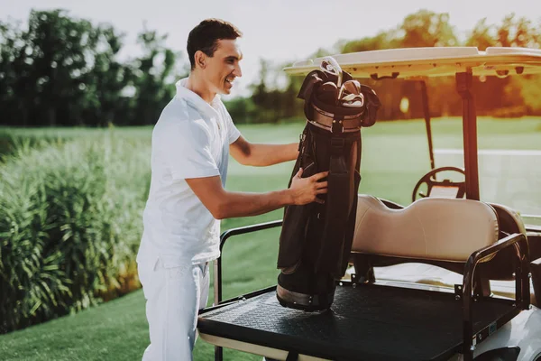 Young Man in White Shirt using Cart on Golf Field. Happy Young Man. Driver with Car. Healthy Lifestyle Concept. Golf Club. Sports in Summer. Vehicle on Field. Family Holiday. Outdoor Fun in Summer.