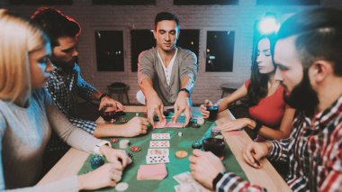 Genç arkadaşlar evde parti poker oynamak. Oyun oynamayı. Kapalı eğlenceli. Genç kız. Genç bir adam. Masada oturuyor. Arkadaş grubu parti. Kapalı faaliyetleri kavramı. Kumar. Kart oyunları.