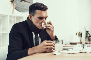 Hasta adam ofiste oturan eşarp ile takım elbiseli. Modern Ofis Yöneticisi. Sağlık kavramı. Modern ofis. Hasta işçi. Office sağlık hizmeti. Ahşap masa. Dijital aygıt. Resepsiyon üstünde Laptop.