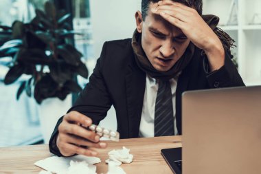 Hasta adam ofiste oturan eşarp ile takım elbiseli. Modern Ofis Yöneticisi. Sağlık kavramı. Modern ofis. Hasta işçi. Office sağlık hizmeti. Ahşap masa. Dijital aygıt. Resepsiyon üstünde Laptop.