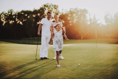Mutlu genç aile yaz aylarında Golf sahasında rahatla. Golf Club civarındaki rahatlatıcı. Spor yaz. Yaz aylarında açık eğlenceli. Aile eğlence kavramı. Sağlıklı yaşam konsepti. Küçük kız. Yeşil çimen.