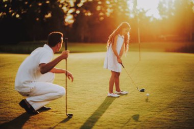 Mutlu genç aile yaz aylarında Golf sahasında rahatla. Golf Club civarındaki rahatlatıcı. Spor yaz. Yaz aylarında açık eğlenceli. Aile eğlence kavramı. Sağlıklı yaşam konsepti. Küçük kız. Yeşil çimen.