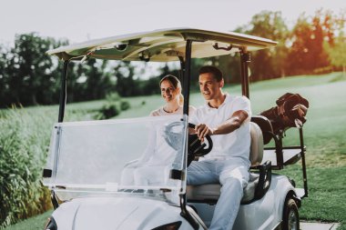 Mutlu genç çift Golf sahasındaki beyaz arabası. Genç aile. Golf Kulübü. Spor yaz. Araç alan üzerinde. Yaz aylarında açık eğlenceli. Araba sürücü. Sağlıklı yaşam konsepti. Tatil çift.