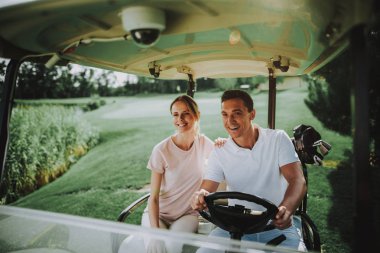 Mutlu genç çift Golf sahasındaki beyaz arabası. Genç aile. Golf Kulübü. Spor yaz. Araç alan üzerinde. Yaz aylarında açık eğlenceli. Araba sürücü. Sağlıklı yaşam konsepti. Tatil çift.