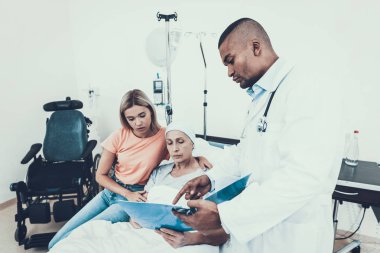Anne olan kadın. Kanser hastası. Doktor tıbbi geçmişini tutmak. Kadın üzgün. Ward doktor. Kadın rehabilitasyon uğrar. Kanser için tedavi sonrası. Ranza kadınlarda. Doktor kliniğinde. İlişkiler.