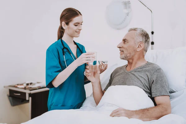 Therapy For Aged Man. People in Clinic. Professional Young Nurse. Interior in Hospital. White Room with Patient and Nurse. Rehab in Clinic. Stethoscope Help Patient in Clinic. Happy Patient and Nurse.