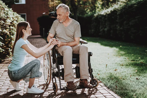 Therapy for Old Man and Young Girl. Concept this Family and Happy. Casual Walk in Nature. Child with Old Man. Diagnosis in Wheelchair. Disease with Aged. Elderly with Young Girl. Family and Old Man.