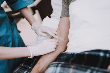 Yaşlı adam tıbbi koğuşta yatak üzerinde yatıyor. Hastanede pislik. Klinikte pislik. Ven hastanede pislik. Ven Kliniği pislik. Hemşire ve hasta beyaz odada. Profesyonel yardım yaşlı adam.