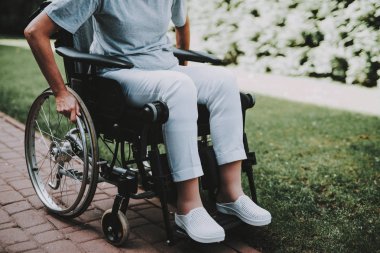 Hastanın rehabilitasyon uğrar. Kanser hastası bir tekerlekli sandalye üzerinde. Kızı olan kadın. Kadın memnun bkz: kızı. Kadın kurtarma. Remisyon. Kliniği. Kanser hastası. Eller arkada tekerlekleri.