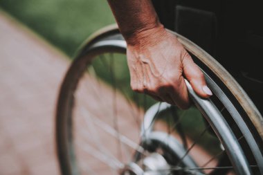 Hastanın rehabilitasyon uğrar. Kanser hastası bir tekerlekli sandalye üzerinde. Kızı olan kadın. Kadın memnun bkz: kızı. Kadın kurtarma. Remisyon. Kliniği. Kanser hastası. Eller arkada tekerlekleri.