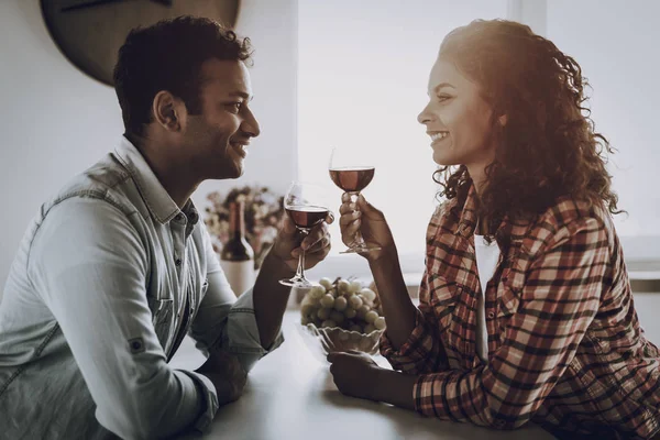 Afro American Couple Drinking Wine On In Kitchen. Weekend Concept. Family Holiday Resting. Romantic Date. Cheerful Sweethearts. Glass Of Wine. Happy Together. Looking At Each Other.