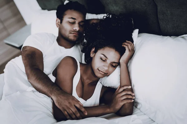 Afro American Couple Are Sleeping In The Bed. Resting Together. Hanging Each Other. Hoiday Leisure. Heads On Pillows. Eyes Closed. Morning Dreaming. Weekend Relaxing. Family Harmony.