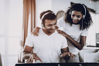 Afro American Couple Listening With Headphones Synthesizer Playing. Happy Songwriter. Morning Leisure. Digital Format Sound Record. Working Musician. Musical Hobby. Hands On Keyboard.