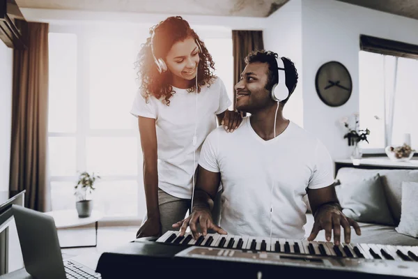 Afro American Couple Listening With Headphones Synthesizer Playing. Happy Songwriter. Morning Leisure. Digital Format Sound Record. Working Musician. Musical Hobby. Hands On Keyboard.