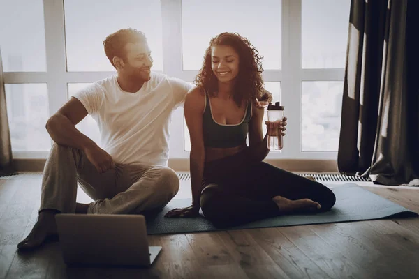Afro American Couple Sitting On Gym Carpet With Laptop. Healthy Lifestyle. Shape Sportswear. Attractive Athletes. Physical Healthcare. Help Each Other. Have A Break. Morning Fitness.