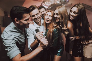 Çocuklar yalnız. Büyük ruh. Genç insanlar. Dans kulübü. Şarkı söyle. Mikrofon. Modaya uygun Modern gece kulübü. Parti Maker. Doğum günü. Karaoke Club. Kutlama. Yakışıklı adam. Güzel kızlar. İnsanlar dans.