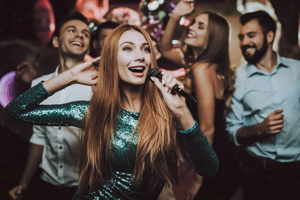 stock image Trendy Nightclub. Handsome Men. Beautiful Girls. Woman in Green. Dress. Singing Songs. Friends at Karaoke Club. Solo. Karaoke Club. Celebration. Smiling Girl. Have Fun. Background. Cheerful. Smile.