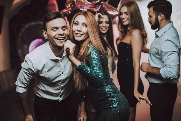 Düet. Gözde gece kulübü. İyi eğlenceler. Yeşil kadında. Elbise. Arka plan. Neşeli. Gülümse. Gülümseyen Girl.Singing şarkılar. Yakışıklı adam. Güzel kızlar. Arkadaşlar Karaoke kulüpte. Karaoke Club. Kutlama.