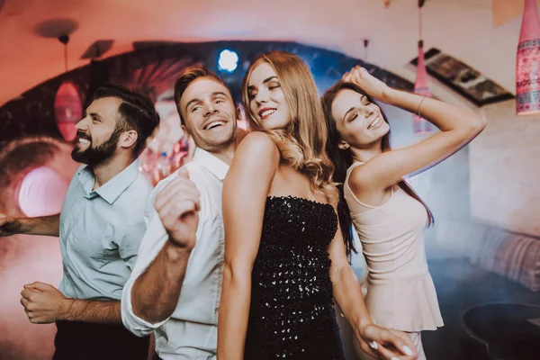 Dancing with Friends. Bar. Handsome Man.Beautiful. Dancing in Club. Man Dancing with Woman. Foreground. Singing Friends behind. Young People. Karaoke Club. Dancing People. Great Mood. Smiling Girl.