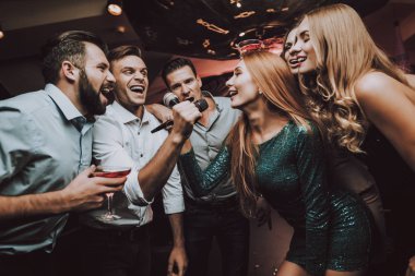 Düet. Gözde gece kulübü. İyi eğlenceler. Ledy yeşil. Elbise. Arka plan. Neşeli. Gülümse. Gülümseyen Girl.Singing şarkılar. Yakışıklı adam. Güzel kızlar. Arkadaşlar Karaoke kulüpte. Karaoke Club. Kutlama.