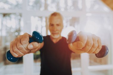 Yaşlı halter tutun. Tedavi jimnastiği. Bakım evi. Yeteneklerine emin görünüyor. Adam etkin emekli. İyi eğlenceler. Spor üniforma giydiği bildirildi. Sağlık yaşam tarzı. Egzersizleri. Hasta gülümseyen.