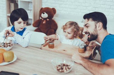 Çocuk yetiştirme. Çocuk. Gevreği süt ile. Chair.Father iki erkek çocuk. Kahvaltı. Baba. Adam geçirdiği zaman. Oğulları. Nişanlı. Delisious yiyecek. Mutlu birlikte. Serbest zaman. Portakal. Gülümseyen çocuklar.