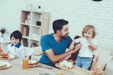 Babası iki çocuklar. Ev zamanı. Baba. Suyu. Sahanda yumurta. Sandviç. Mutlu birlikte. Delisious yiyecek. Gülümse. Zaman harcıyor. Serbest zaman. Gülümseyen çocuklar. Kahvaltı. Erkek çocuk koltuğu üzerinde.