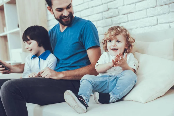 Parlak saç bebekle. Aile. Çocukluk. Zaman harcıyor. Mutlu birlikte. Serbest zaman. Gülümseyen çocuklar. Baba. Babası iki çocuklar. Adam gülümseme. Ev zamanı. Bir Video göster. Teknoloji. Tablet.