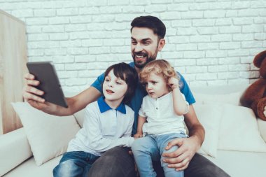 Mutlu birlikte. Serbest zaman. Teknoloji. Aile. Çocukluk. Tablet. Zaman harcıyor. Gülümseyen çocuklar. Baba. Babası iki çocuklar. Adam gülümseme. Ev zamanı. Parlak saç bebekle. Bir Video göster.