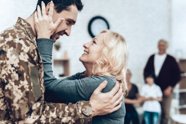 Askerlik hizmeti üzerinden bir adam geri döner. Aile toplantısı. Savaştan bırakarak. Aile ile kucaklamak. Kamuflaj üniforma. Anne asılı. Gösterilen duygular. Vatansever dönüş. Asker duygu.