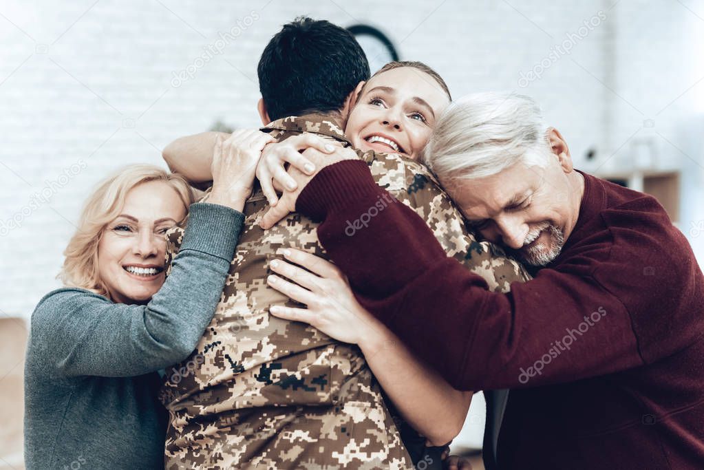 A Man Returns From The Military Service. Family Meeting. Leaving From War. Embrace With Family. Camouflage Uniform. Family Hanging. Feelings Showing. Patriotic Comeback. Soldier Emotion.