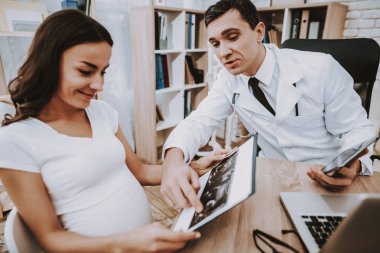 Annelik. Dizüstü bilgisayar. Danışma. Kadın hastalıkları. Hastane. Ultrason incelemesi. Doktor. Kliniği. Jinekolog. Tıbbi yardım. Kadın. Beyaz önlük. İyi eğlenceler. Hamile kızı. Doğum sırasında. Göbek. Fan.