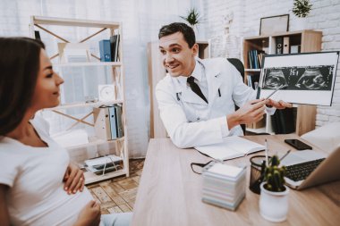 Dizüstü bilgisayar. Danışma. Ultrason incelemesi. Doktor. Kliniği. Jinekolog. Tıbbi yardım. Kadın. Beyaz önlük. İyi eğlenceler. Hamile kızı. Kadın hastalıkları. Hastane. Doğum sırasında. Annelik. Göbek. Fan.
