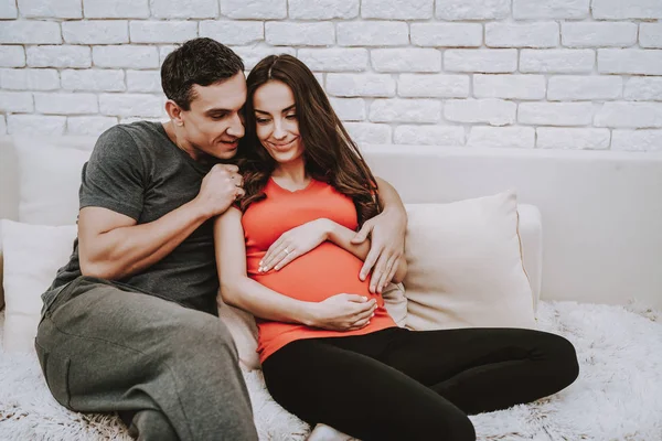 丈夫和怀孕的妻子 一起在沙发上 彼此相爱 快乐在一起 家庭生活 — 图库照片