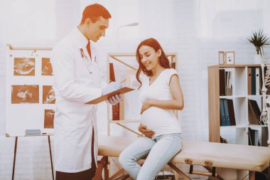 Hastane. Doktor reçete yazıyor. Kağıt. Danışma. Doğum sırasında. Göbek. Hamile kadın. Gülümseyerek. Kliniği. Jinekolog. Beyaz önlük. Doktor. Kliniği. Annelik. Dizüstü bilgisayar. İyi eğlenceler. Tıbbi yardım.