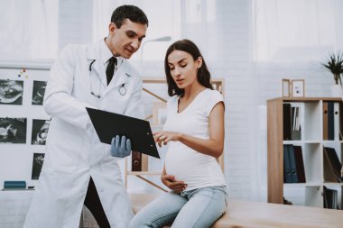 Kağıt. Danışma. Doktor reçete yazıyor. Hastane. Doğum sırasında. Göbek. Hamile kadın. Gülümseyerek. Kliniği. Jinekolog. Beyaz önlük. Doktor. Kliniği. Annelik. Dizüstü bilgisayar. İyi eğlenceler. Tıbbi yardım.