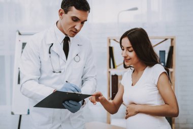 Doktor reçete yazıyor. Kağıt. Danışma. Hastane. Doğum sırasında. Göbek. Hamile kadın. Gülümseyerek. Kliniği. Jinekolog. Beyaz önlük. Doktor. Kliniği. Annelik. Dizüstü bilgisayar. İyi eğlenceler. Tıbbi yardım.