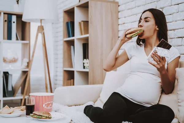 Comida Menina Grávida Come Hambúrguer Chocolate Senta Sofá Para Casa — Fotografia de Stock