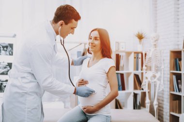 Doktor inceliyor. İyi eğlenceler. Doğum sırasında. Göbek. Fan. Danışma. Hastane. Hamile kadın. Gülümseyerek. Kliniği. Jinekolog. Beyaz önlük. Doktor. Kliniği. Annelik. Dizüstü bilgisayar. Ultrason. Tıbbi yardım.