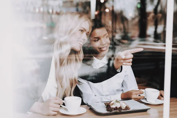 カフェ ブロンドの女の子 ムラート 座っています コーヒーを飲みます ウィンドウ 楽しんでください プレートの食品 お客様に食品 残りの部分 — ストック写真