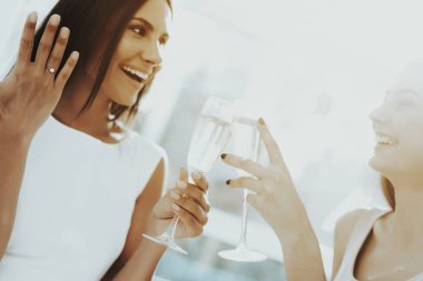 Kızlar tavuk taraf şampanya içiyor. Düğün öncesi kavramı. Güzel parlak gülüş. Gelinle dinleniyor. Güneşli bir gün. İyi bir ruh hali. Genç ve çekici. Mutlu tatil. Uzun saç.