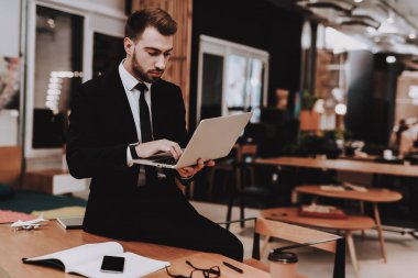 Çalışma alanı. Takım elbise. Dizüstü bilgisayar. Otur. Beyin fırtınası. Genç bir adam. İş adamı. Ofiste çalışıyor. Yaratıcı işçi. Fikirler oluşturur. İş adamları. İlham. Gevşeme. Hobi. Rahat Office.