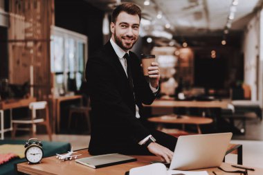 Kahve içme. Takım elbise. Dizüstü bilgisayar. Otur. Beyin fırtınası. Genç bir adam. İş adamı. Ofiste çalışıyor. Yaratıcı işçi. Fikirler oluşturur. İş adamları. Çalışma alanı. İlham. Rahat Office.