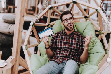 Uçak bileti. Kahve. Fikirler oluşturun. İlham. Yaratıcı işçi. Sandalyeye asılı. Otur. Beyin fırtınası. Genç bir adam. İş adamı. Ofiste çalışıyor. İş adamları. Çalışma alanı. Gevşeme. Rahat.