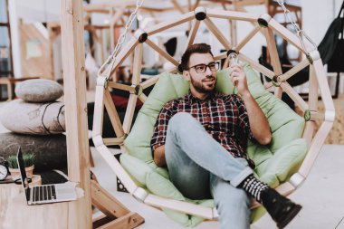 Ampul. Sandalyeye asılı. Dizüstü bilgisayar. Otur. Beyin fırtınası. Genç bir adam. İş adamı. Ofiste çalışıyor. Yaratıcı işçi. Fikirler oluşturur. İş adamları. Çalışma alanı. İlham. Gevşeme. Rahat Office.