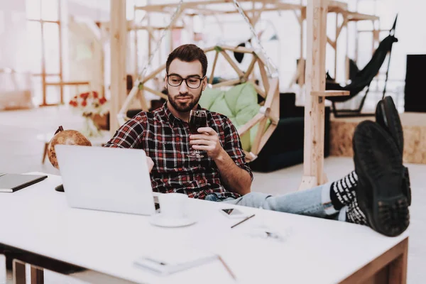 Bir bardak şarap. Ayakları üzerinde tablo. Dizüstü bilgisayar. Rahat. Proje. Otur. Beyin fırtınası. Genç bir adam. İş adamı. İş. Office. Yaratıcı işçi. Fikirler. İş adamları. Çalışma alanı. İlham. Küre.