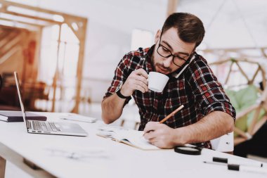 Fikirler. Kahve içme. Telefon. Dizüstü bilgisayar. Otur. Beyin fırtınası. Genç bir adam. İş adamı. İş. Office. Yaratıcı işçi. İş adamları. Çalışma alanı. İlham. Stres. Gevşeme. Hobi. Rahat Office.