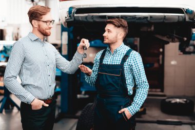 Car Owner Gives Keys To The Auto Mechanic In Garage. Trust Showing. Professional Uniform. Confident Engineer Stare. Repair Young Specialist. Service Station Concept. Machine Repairing. clipart