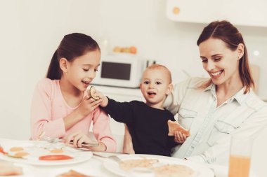 Aile yeme. Anne küçük oğlu mutfak At besleniyor. Aile ilişki kavramı. Kahvaltı sırasında eğleniyor. Sabah Nutricion. Kaşık besleyen. Mutlu çocukluk kavramı. Öğle vakti.